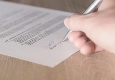 Main signant un document avec un stylo